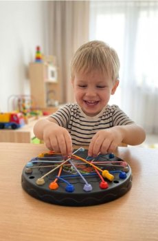 Гра на спритність – Дошка з еластичними гумками для тягнення - різнобарвний